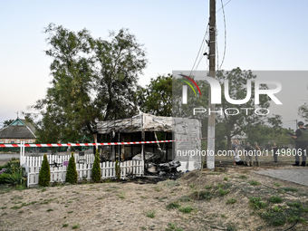 Law enforcers are outside the Levada children's cafe in the central park damaged by a Russian artillery shell strike in Malokaterynivka vill...