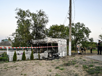 Law enforcers are outside the Levada children's cafe in the central park damaged by a Russian artillery shell strike in Malokaterynivka vill...