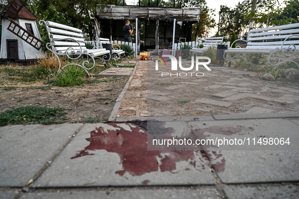 A blood stain of one of the children wounded by a Russian artillery shell strike on the Levada cafe is on the ground in the central park in...