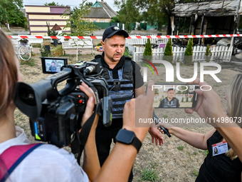 Serhii Volyk, a police officer of the Kushuhum community who administers first aid to wounded children, speaks to the press near the Levada...