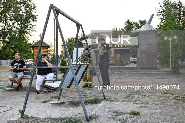 Law enforcers are outside the Levada children's cafe in the central park damaged by a Russian artillery shell strike in Malokaterynivka vill...