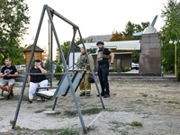 Law enforcers are outside the Levada children's cafe in the central park damaged by a Russian artillery shell strike in Malokaterynivka vill...