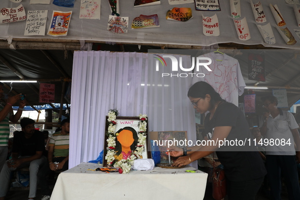 A medical student lights a candle as she protests against the rape and murder of a PGT woman doctor at Government-run R G Kar Medical Colleg...