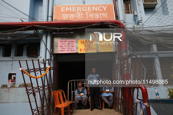 Security officials guard outside the medical emergency ward under a few posters at Government-run R G Kar Medical College & Hospital in Kolk...