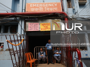 Security officials guard outside the medical emergency ward under a few posters at Government-run R G Kar Medical College & Hospital in Kolk...