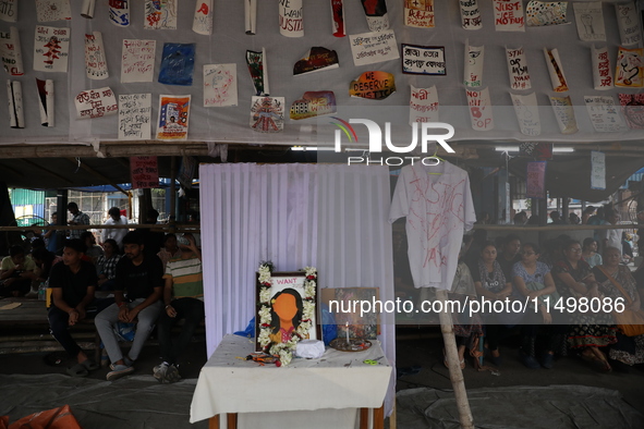 Medical students sit behind an altar of framed images as they protest against the rape and murder of a PGT woman doctor at Government-run R...