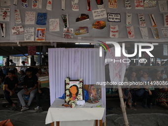 Medical students sit behind an altar of framed images as they protest against the rape and murder of a PGT woman doctor at Government-run R...