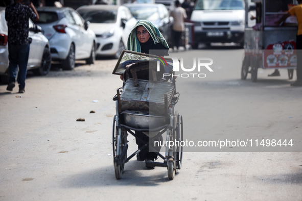 Palestinians flee with their belongings in Deir el-Balah, Gaza Strip, on August 21, 2024, amid the ongoing conflict between Israel and the H...