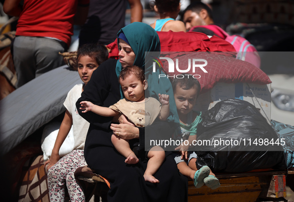 Palestinians flee with their belongings in Deir el-Balah, Gaza Strip, on August 21, 2024, amid the ongoing conflict between Israel and the H...