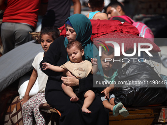 Palestinians flee with their belongings in Deir el-Balah, Gaza Strip, on August 21, 2024, amid the ongoing conflict between Israel and the H...