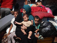 Palestinians flee with their belongings in Deir el-Balah, Gaza Strip, on August 21, 2024, amid the ongoing conflict between Israel and the H...