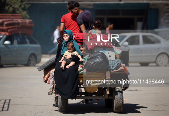 Palestinians flee with their belongings in Deir el-Balah, Gaza Strip, on August 21, 2024, amid the ongoing conflict between Israel and the H...