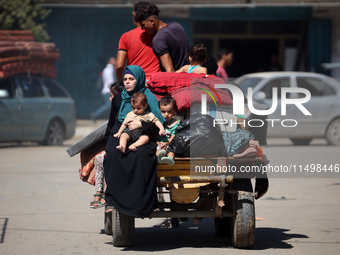 Palestinians flee with their belongings in Deir el-Balah, Gaza Strip, on August 21, 2024, amid the ongoing conflict between Israel and the H...