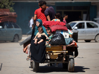 Palestinians flee with their belongings in Deir el-Balah, Gaza Strip, on August 21, 2024, amid the ongoing conflict between Israel and the H...