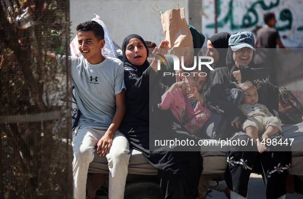 Palestinians flee with their belongings in Deir el-Balah, Gaza Strip, on August 21, 2024, amid the ongoing conflict between Israel and the H...