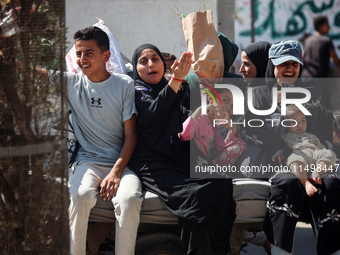 Palestinians flee with their belongings in Deir el-Balah, Gaza Strip, on August 21, 2024, amid the ongoing conflict between Israel and the H...