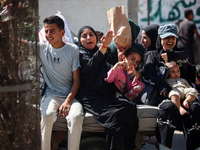 Palestinians flee with their belongings in Deir el-Balah, Gaza Strip, on August 21, 2024, amid the ongoing conflict between Israel and the H...