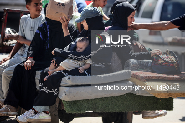 Palestinians flee with their belongings in Deir el-Balah, Gaza Strip, on August 21, 2024, amid the ongoing conflict between Israel and the H...