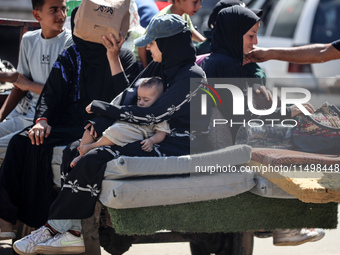 Palestinians flee with their belongings in Deir el-Balah, Gaza Strip, on August 21, 2024, amid the ongoing conflict between Israel and the H...