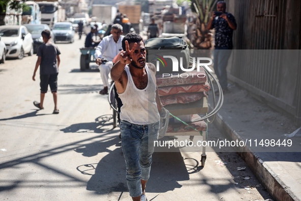 Palestinians flee with their belongings in Deir el-Balah, Gaza Strip, on August 21, 2024, amid the ongoing conflict between Israel and the H...