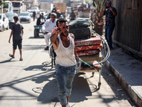 Palestinians flee with their belongings in Deir el-Balah, Gaza Strip, on August 21, 2024, amid the ongoing conflict between Israel and the H...