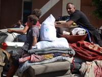 Palestinians flee with their belongings in Deir el-Balah, Gaza Strip, on August 21, 2024, amid the ongoing conflict between Israel and the H...