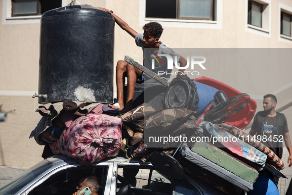 Palestinians flee with their belongings in Deir el-Balah, Gaza Strip, on August 21, 2024, amid the ongoing conflict between Israel and the H...