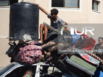 Palestinians flee with their belongings in Deir el-Balah, Gaza Strip, on August 21, 2024, amid the ongoing conflict between Israel and the H...