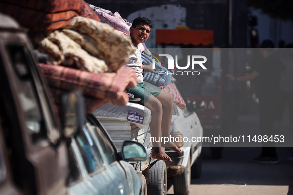 Palestinians flee with their belongings in Deir el-Balah, Gaza Strip, on August 21, 2024, amid the ongoing conflict between Israel and the H...