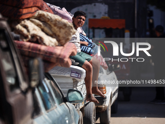 Palestinians flee with their belongings in Deir el-Balah, Gaza Strip, on August 21, 2024, amid the ongoing conflict between Israel and the H...