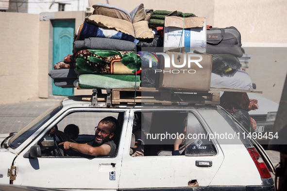 Palestinians flee with their belongings in Deir el-Balah, Gaza Strip, on August 21, 2024, amid the ongoing conflict between Israel and the H...