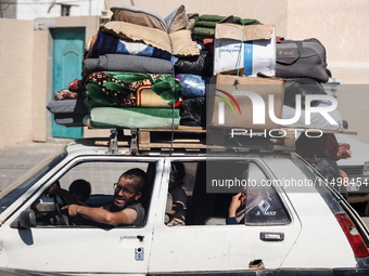 Palestinians flee with their belongings in Deir el-Balah, Gaza Strip, on August 21, 2024, amid the ongoing conflict between Israel and the H...