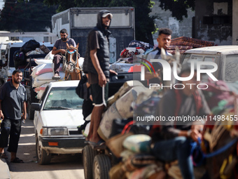 Palestinians flee with their belongings in Deir el-Balah, Gaza Strip, on August 21, 2024, amid the ongoing conflict between Israel and the H...