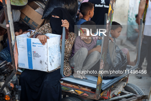 Palestinians flee with their belongings in Deir el-Balah, Gaza Strip, on August 21, 2024, amid the ongoing conflict between Israel and the H...