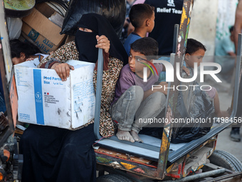 Palestinians flee with their belongings in Deir el-Balah, Gaza Strip, on August 21, 2024, amid the ongoing conflict between Israel and the H...