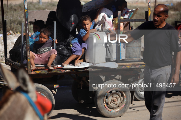 Palestinians flee with their belongings in Deir el-Balah, Gaza Strip, on August 21, 2024, amid the ongoing conflict between Israel and the H...