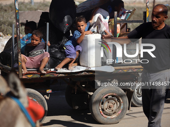 Palestinians flee with their belongings in Deir el-Balah, Gaza Strip, on August 21, 2024, amid the ongoing conflict between Israel and the H...