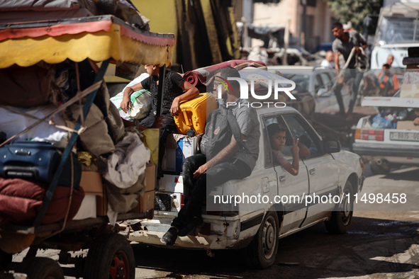 Palestinians flee with their belongings in Deir el-Balah, Gaza Strip, on August 21, 2024, amid the ongoing conflict between Israel and the H...