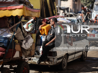 Palestinians flee with their belongings in Deir el-Balah, Gaza Strip, on August 21, 2024, amid the ongoing conflict between Israel and the H...