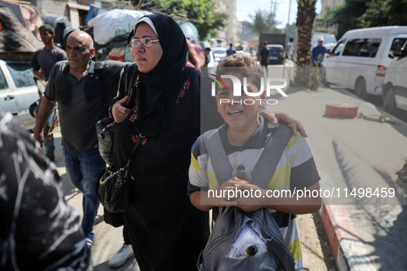 Palestinians flee with their belongings in Deir el-Balah, Gaza Strip, on August 21, 2024, amid the ongoing conflict between Israel and the H...