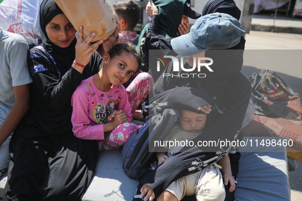 Palestinians flee with their belongings in Deir el-Balah, Gaza Strip, on August 21, 2024, amid the ongoing conflict between Israel and the H...