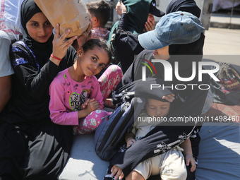 Palestinians flee with their belongings in Deir el-Balah, Gaza Strip, on August 21, 2024, amid the ongoing conflict between Israel and the H...