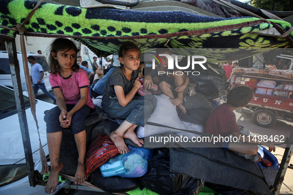 Palestinians flee with their belongings in Deir el-Balah, Gaza Strip, on August 21, 2024, amid the ongoing conflict between Israel and the H...