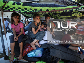 Palestinians flee with their belongings in Deir el-Balah, Gaza Strip, on August 21, 2024, amid the ongoing conflict between Israel and the H...