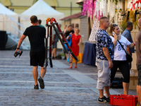 A man with a ladder and a drill is seen on the street in Krakow, Poland, on August 13, 2024. (