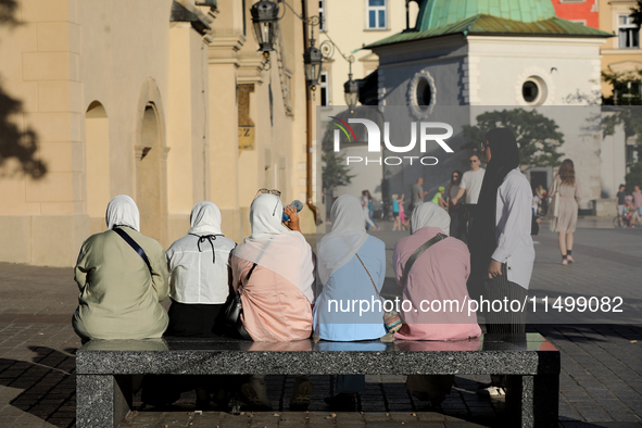 Tourists from the Middle East are seen on the Main Square in Krakow, Poland, on August 13, 2024. 