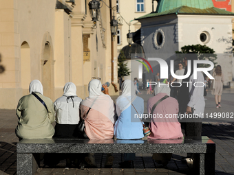 Tourists from the Middle East are seen on the Main Square in Krakow, Poland, on August 13, 2024. (