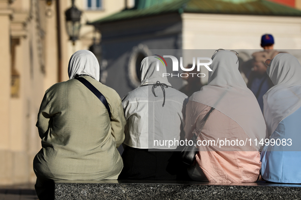 Tourists from the Middle East are seen on the Main Square in Krakow, Poland, on August 13, 2024. 