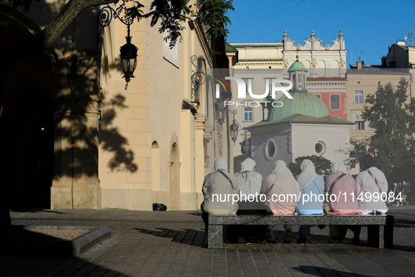 Tourists from the Middle East are seen on the Main Square in Krakow, Poland, on August 13, 2024. 