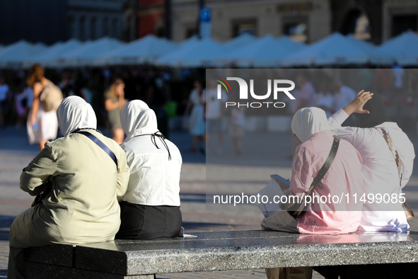 Tourists from the Middle East are seen on the Main Square in Krakow, Poland, on August 13, 2024. 